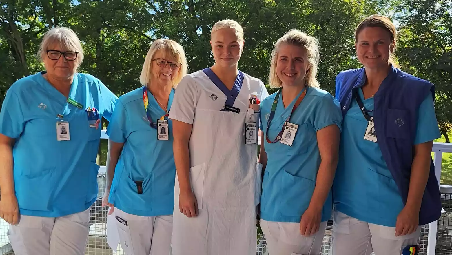 Fem kvinnor i sjuksköterskekläder, tittar in i kameran